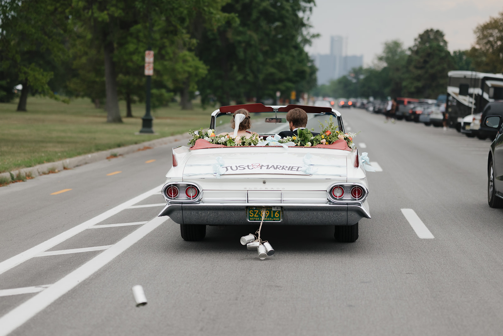Bride and groom in their getaway car riding in downtown Detroit.