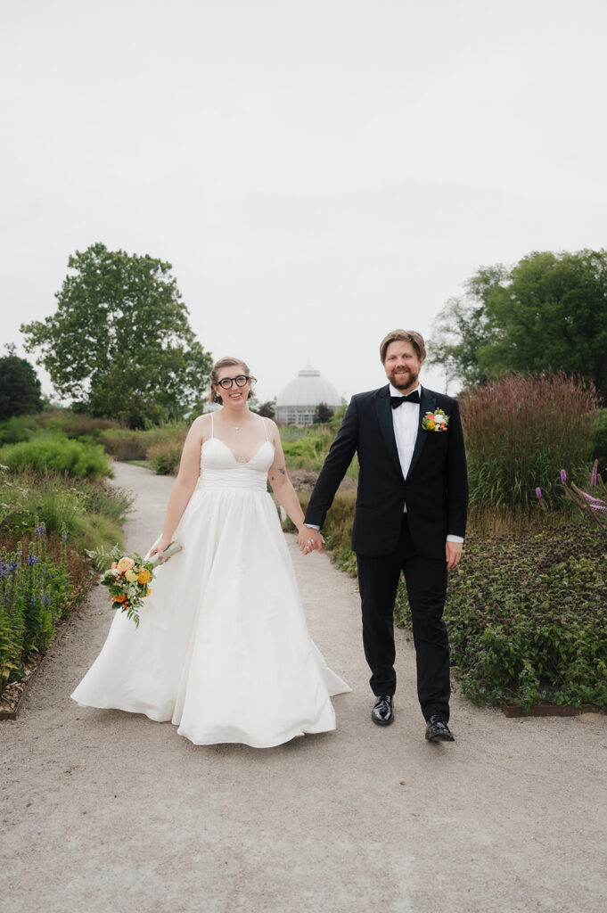 Bride and groom walking down a dirt path at Oudolf Garden in Detroit, Michigan.