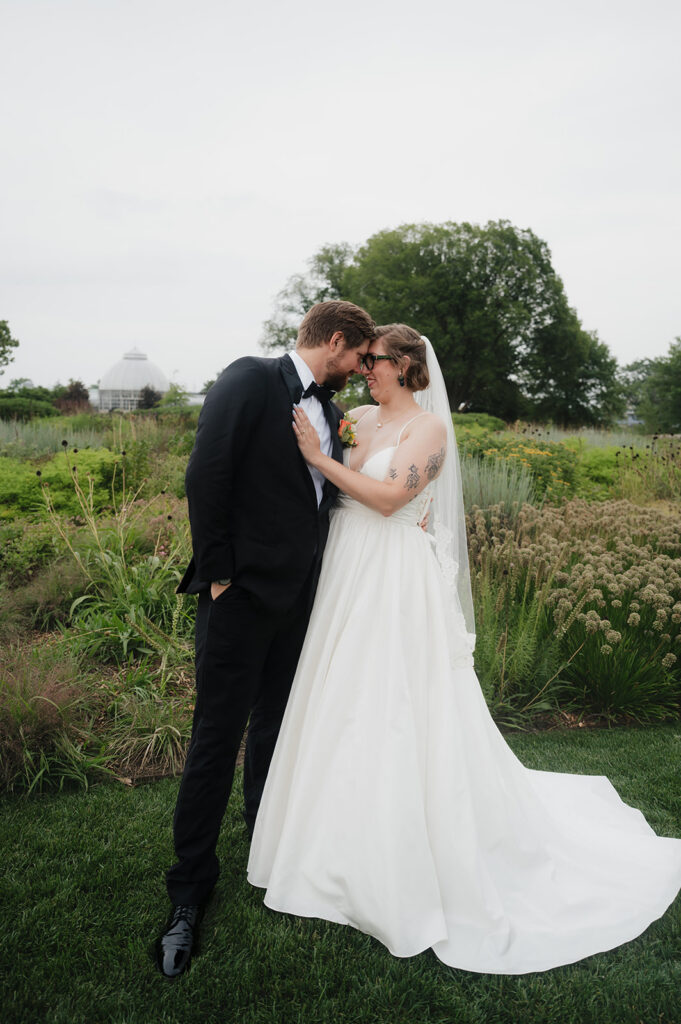 Bride and groom posing outdoors at Oudolf Garden in Detroit, Michigan.