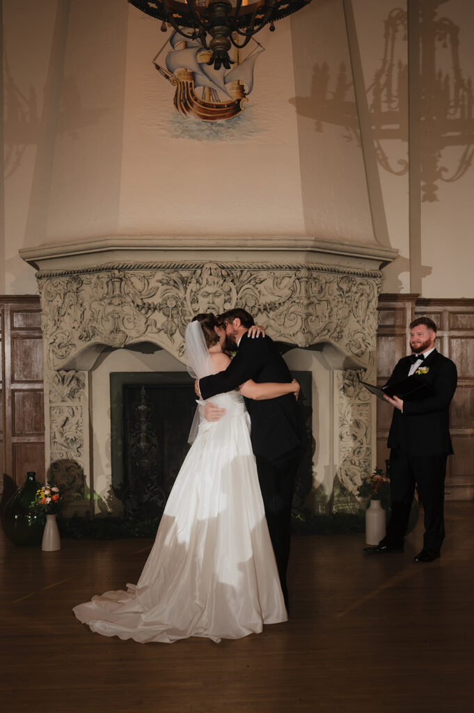 Bride and groom sharing their first kiss at Detroit Yacht Club wedding ceremony.