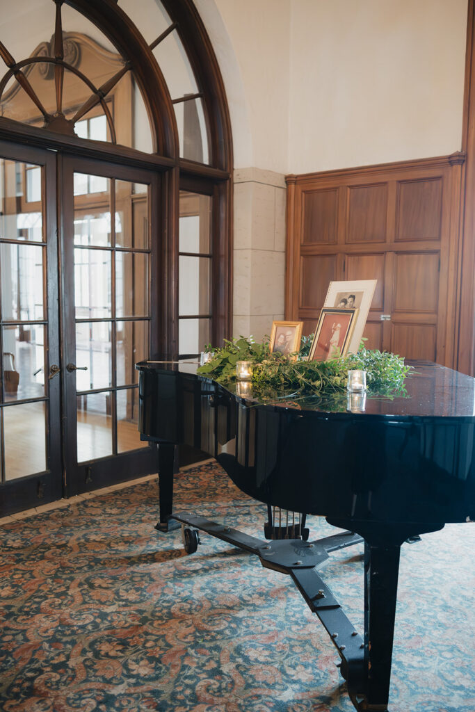Piano decorated with greenery and photos during a Detroit Yacht Club cocktail hour.