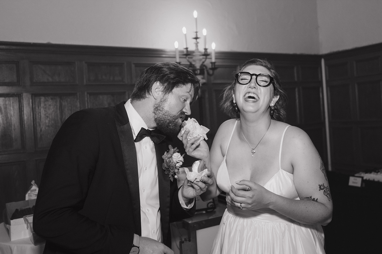 Black and white photo of a bride and groom sharing Cool Jacks ice cream sandwiches during their Detroit Yacht Club wedding reception.