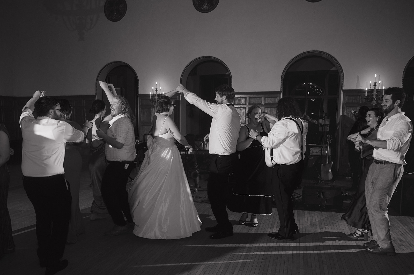 Black and white photo of a bride and groom dancing with their guests during their Detroit Yacht Club wedding reception.