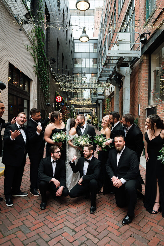 Bridal party gathered together in downtown Detroit at The Belt alley celebrating around bride and groom.
