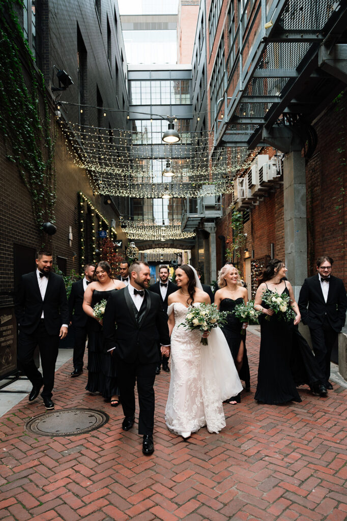 Bridal party walking together in downtown Detroit at The Belt with bride and groom in the center.