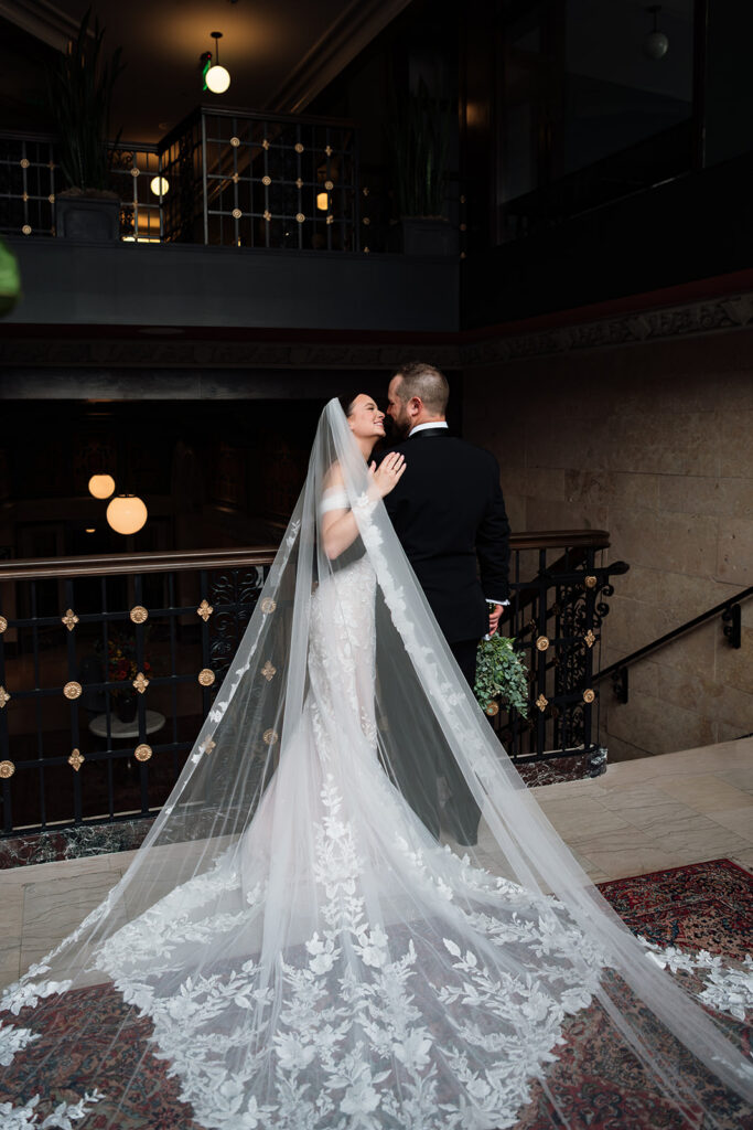 Bride and groom posed near a railing at Element by Westin Detroit.