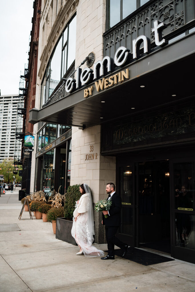 Bride and groom walking out of Element by Westin in Downtown Detroit.