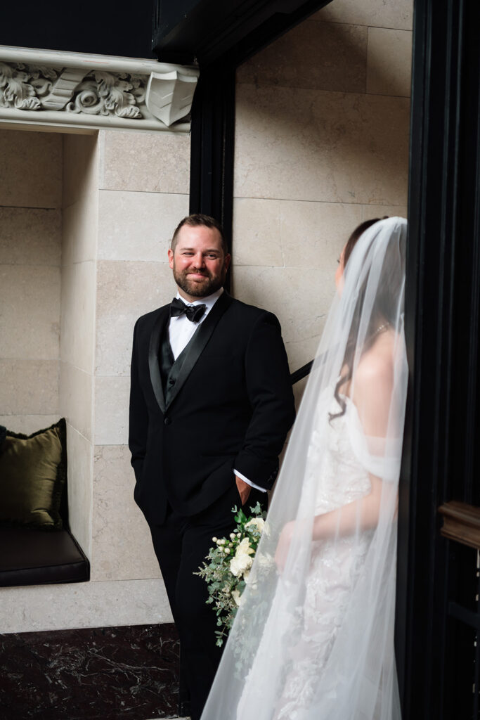 Groom smiling at his bride as they pose for portraits at Element by Westin Detroit.