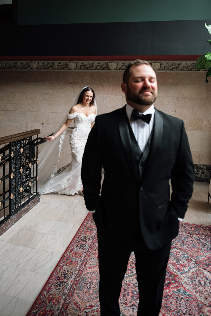 Bride walking up behind the groom before sharing a first look at Element by Westin Detroit.