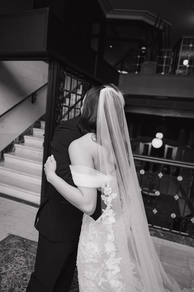 Black and white portrait of a bride and groom hugging after sharing a first look at Element by Westin Detroit.