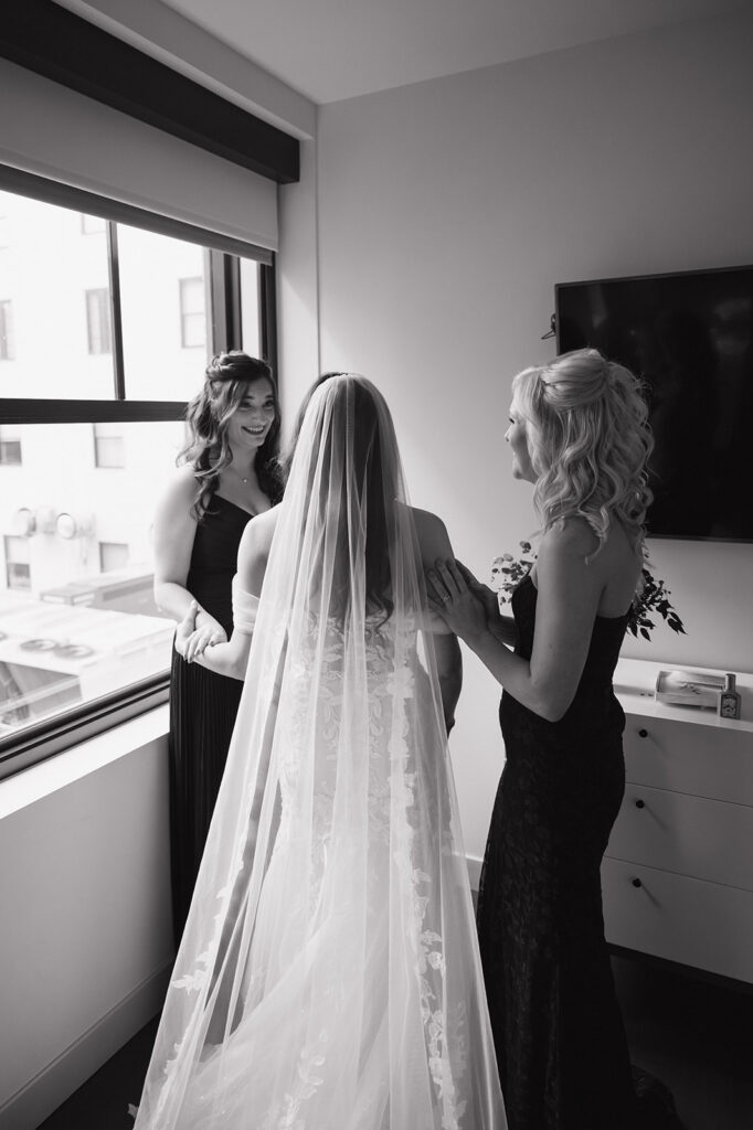 Bride with bridesmaids sharing a moment while getting ready at Element by Westin Detroit.