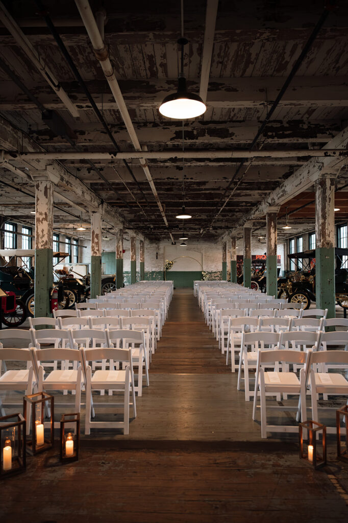 Ceremony setup with white chairs inside Ford Piquette Avenue Plant wedding venue in Detroit.