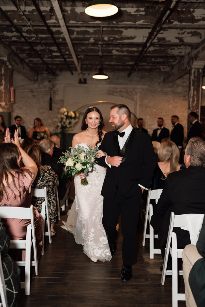 Bride and groom walking down the aisle after ceremony at Ford Piquette Avenue Plant wedding.