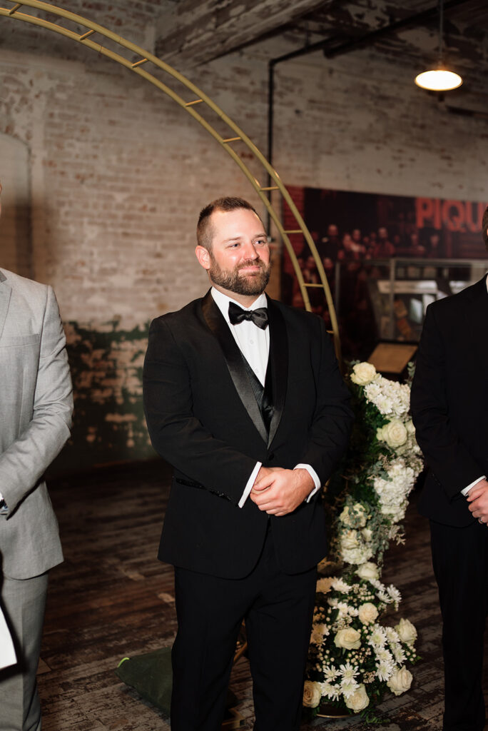 Groom standing at altar during Ford Piquette Avenue Plant wedding ceremony.