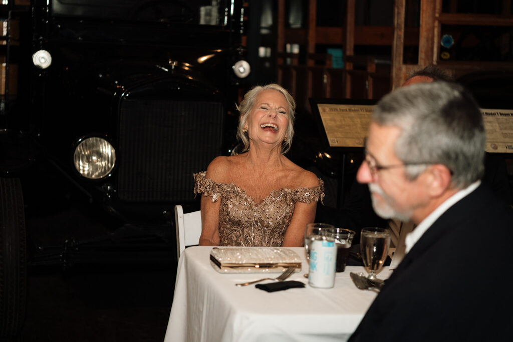 Guests laughing during wedding reception speeches.