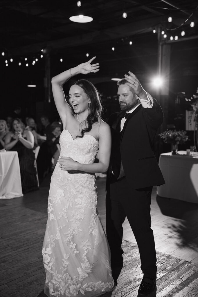 Bride and groom sharing first dance under string lights at Ford Piquette Avenue Plant reception.