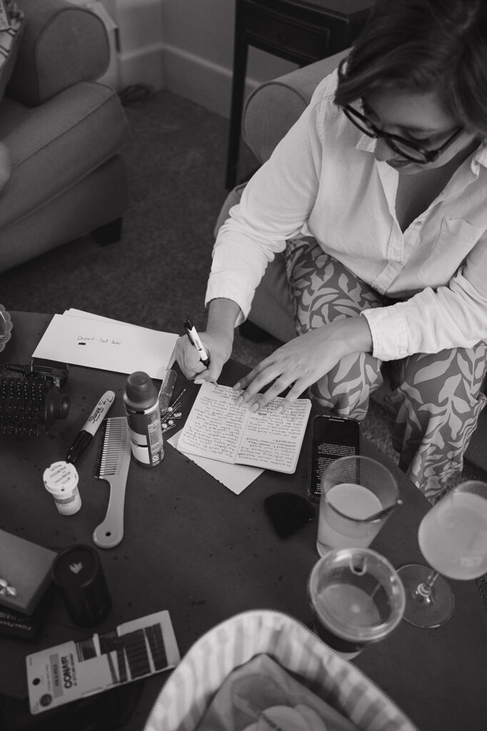 Black and white candid photo of a bride writing her vows.