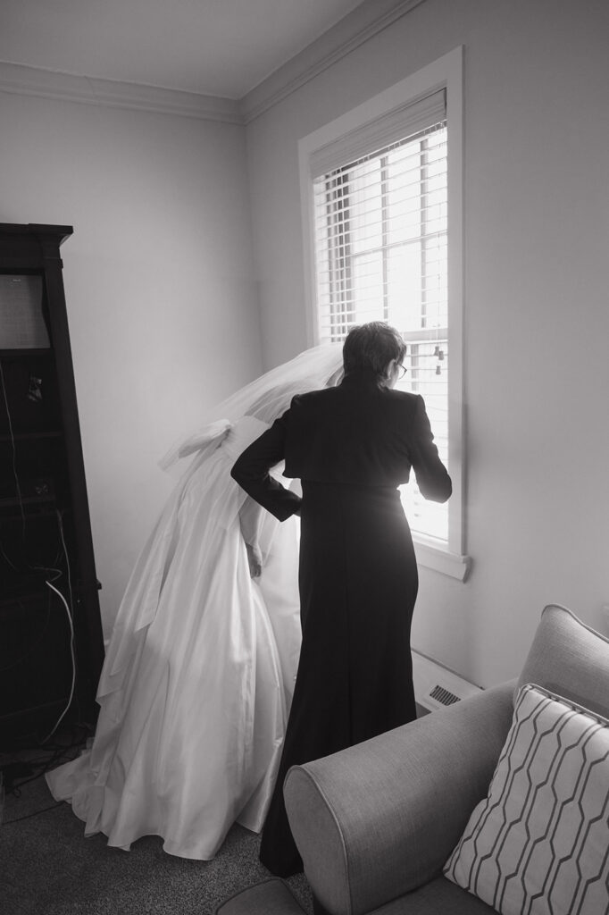 Black and white photo of a bride and her mother looking out the window.