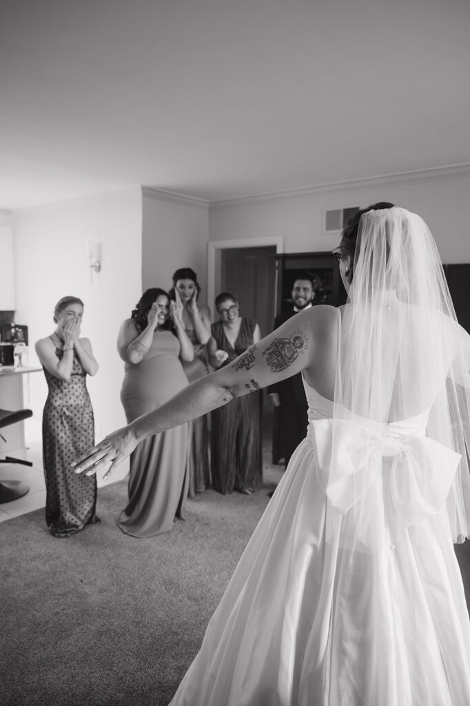 Black and white photo of a bridesmaids getting emotional during the first look with the bride.