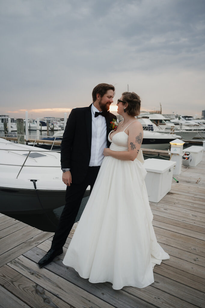 Bride and groom posing on the dock at Detroit Yacht Club for their sunset wedding portraits.