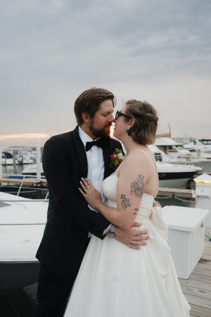 Bride and groom posing on the dock at Detroit Yacht Club for their sunset wedding portraits.