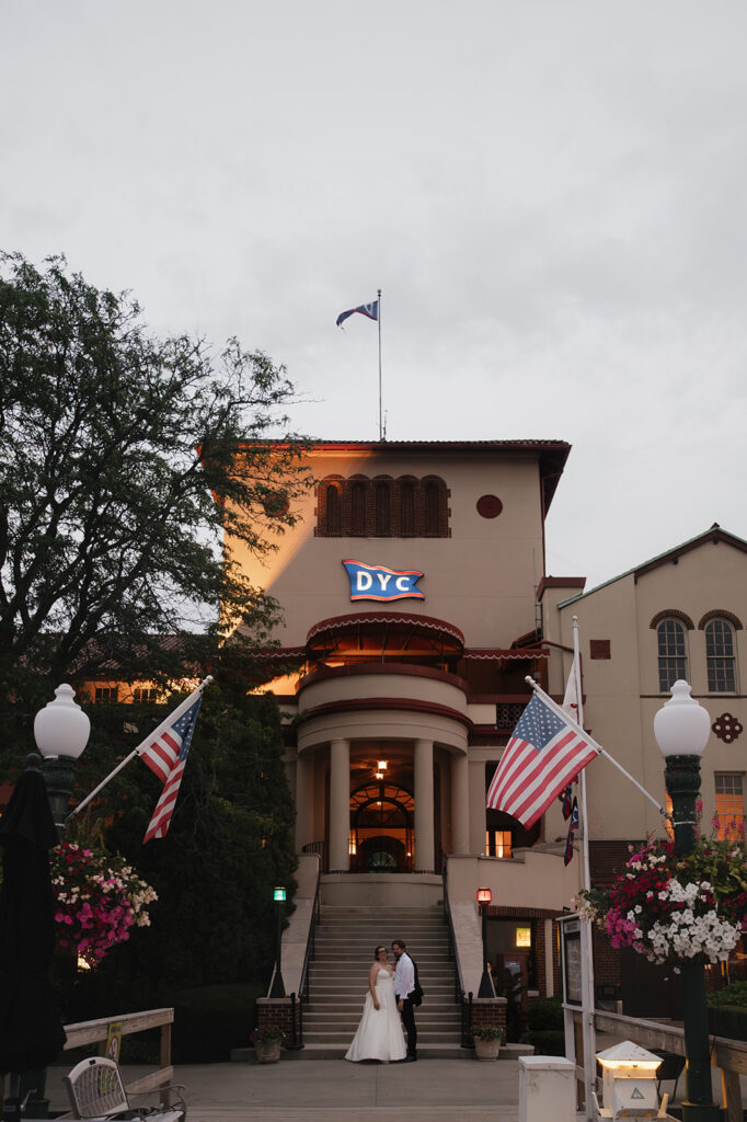 Bride and groom posing in front of the Detroit Yacht Club for their wedding portraits.