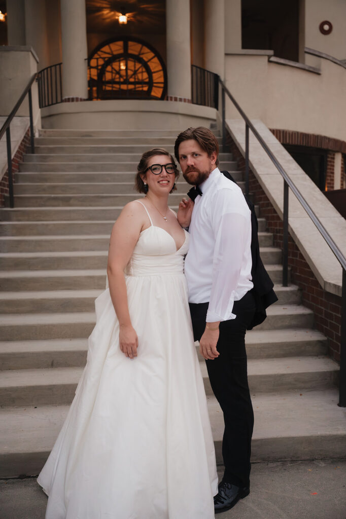 Bride and groom posing in front of the stairs at the Detroit Yacht Club for their wedding portraits.
