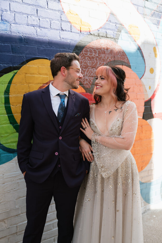 Bride and groom posing in front of colorful murals during their Ferndale Michigan wedding.