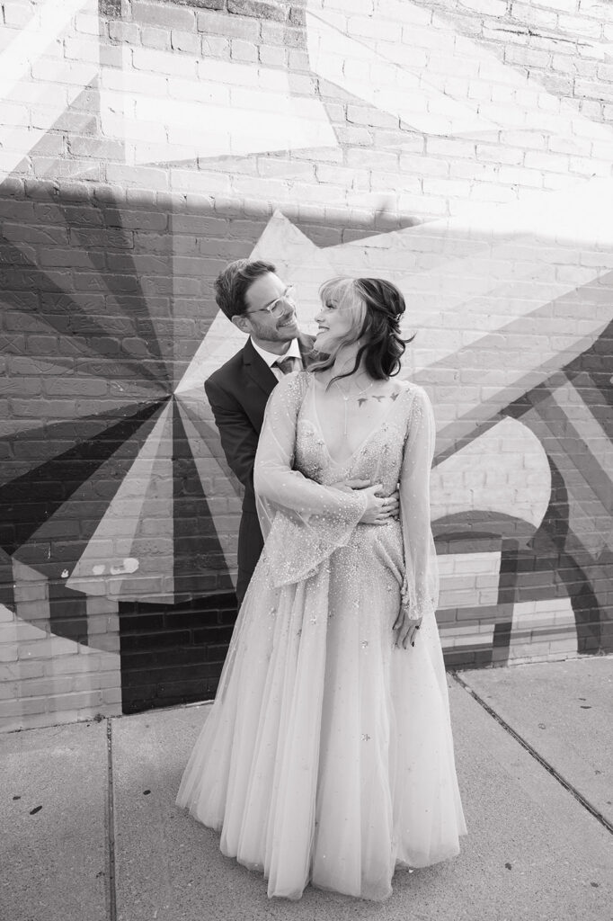 Bride and groom smiling together in a black and white portrait during their Ferndale Michigan wedding.