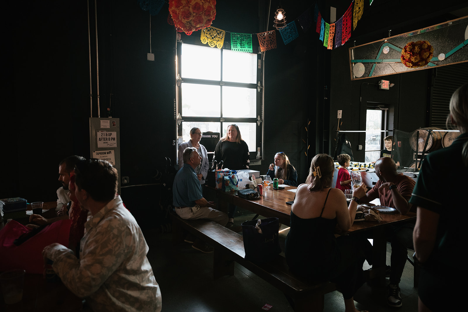 Guests mingling at Dog and Pony Show Brewing during a laid-back rehearsal dinner.