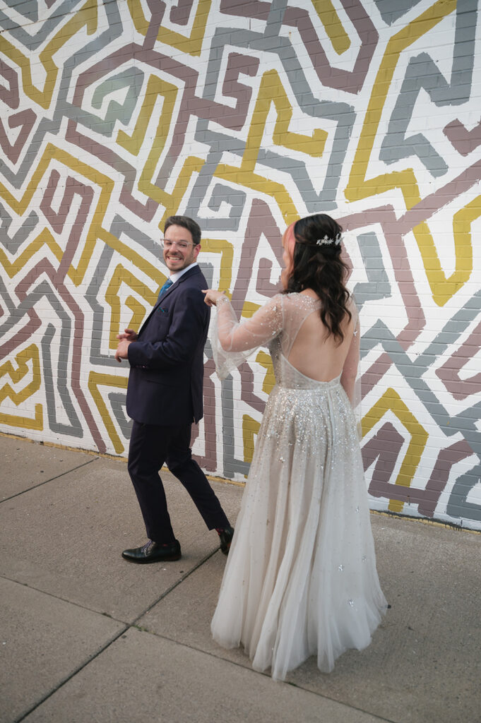 Bride tapping groom on the shoulder during their first look before their Ferndale Michigan wedding.