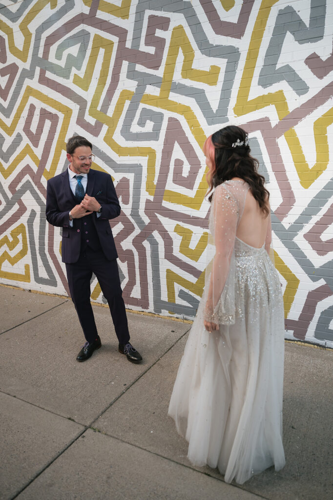 Groom seeing bride during their first look outside Detroit Fleat in Ferndale, Michigan.