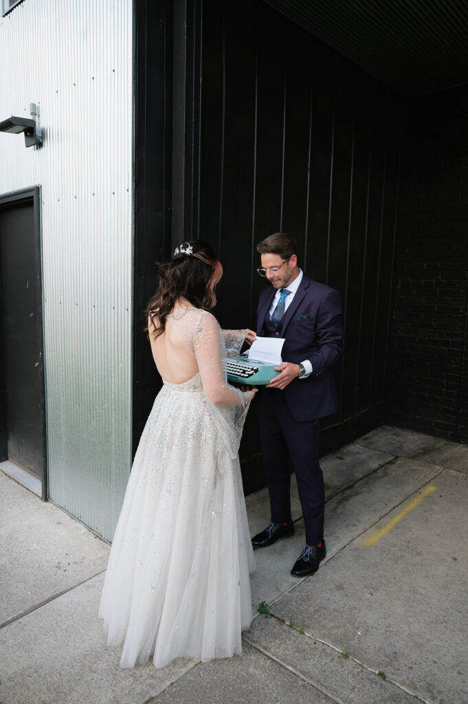 Bride reading a typed letter from a vintage typewriter during their Ferndale Michigan wedding.