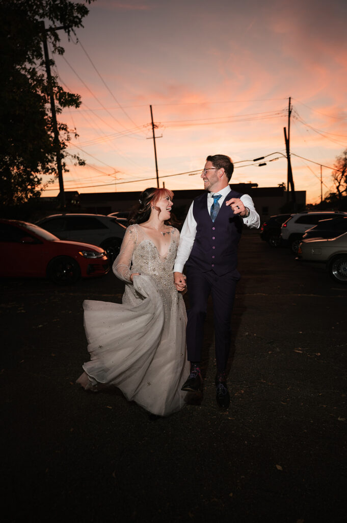 Bride and groom laughing together at sunset during their Detroit Fleat wedding.