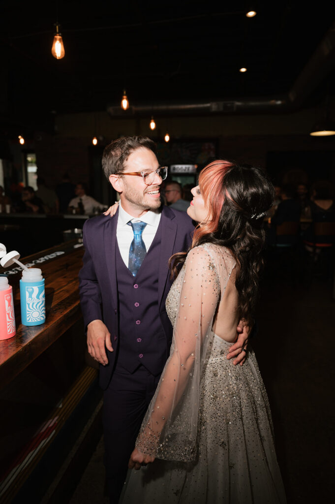 Bride and groom posing for a photo during their Detroit Fleat wedding reception.