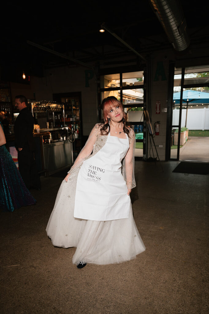 Bride wearing a saving the dress apron during the reception.