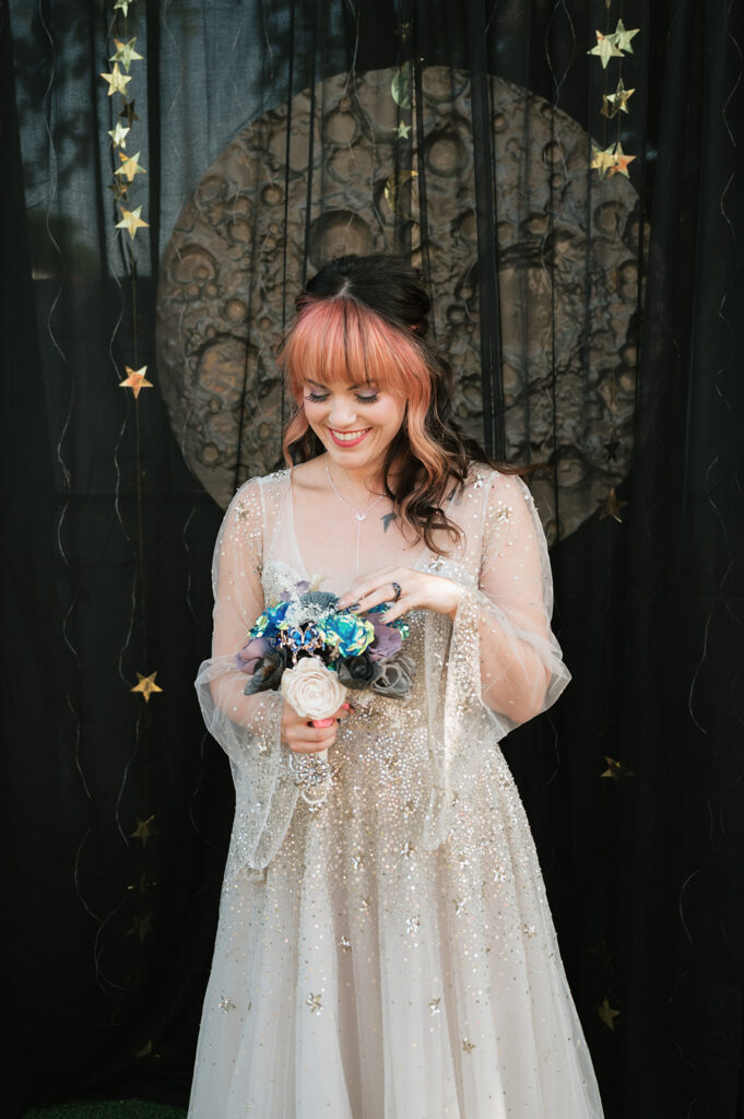 Bride posing ofr her space-themed wedding portraits holding a Sola Wood Flower bouquet.