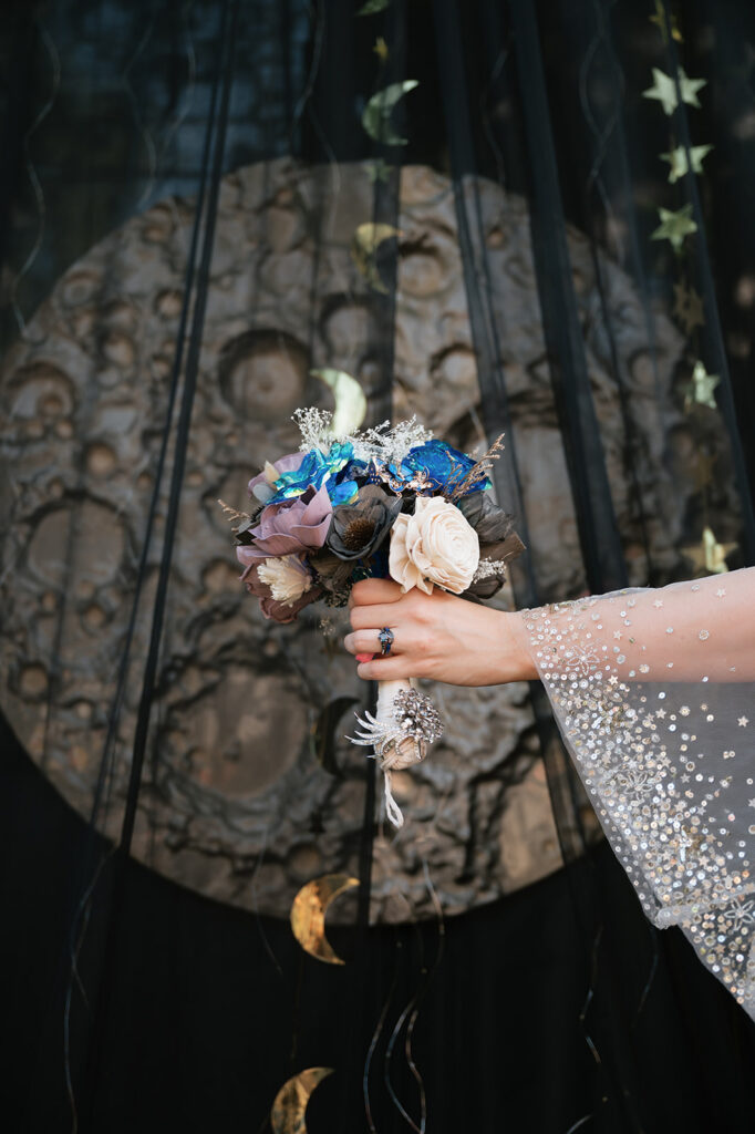 Bride holding up her space-themed wedding bouquet.