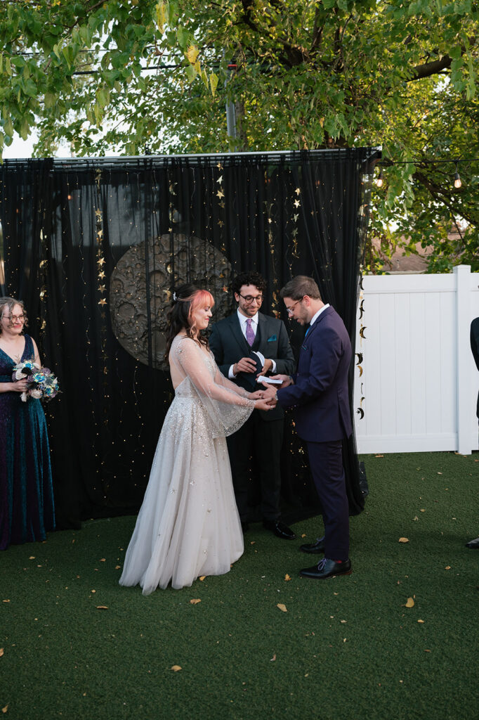 Bride and groom holding hands during their Ferndale, Michigan wedding ceremony at Detroit Fleat.