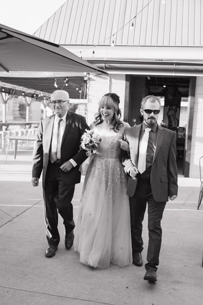 Bride walking down the aisle with family during her Ferndale Michigan wedding ceremony.