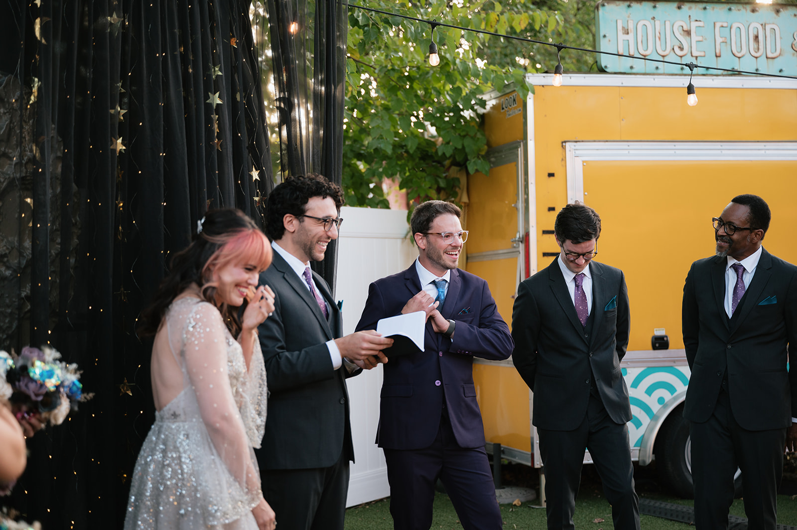Bride and groom laughing with their wedding party during their Detroit Fleat wedding ceremony.