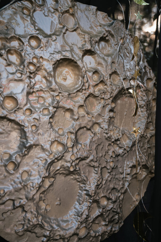 Close-up of handmade moon ceremony backdrop for a space-themed Ferndale Michigan wedding.
