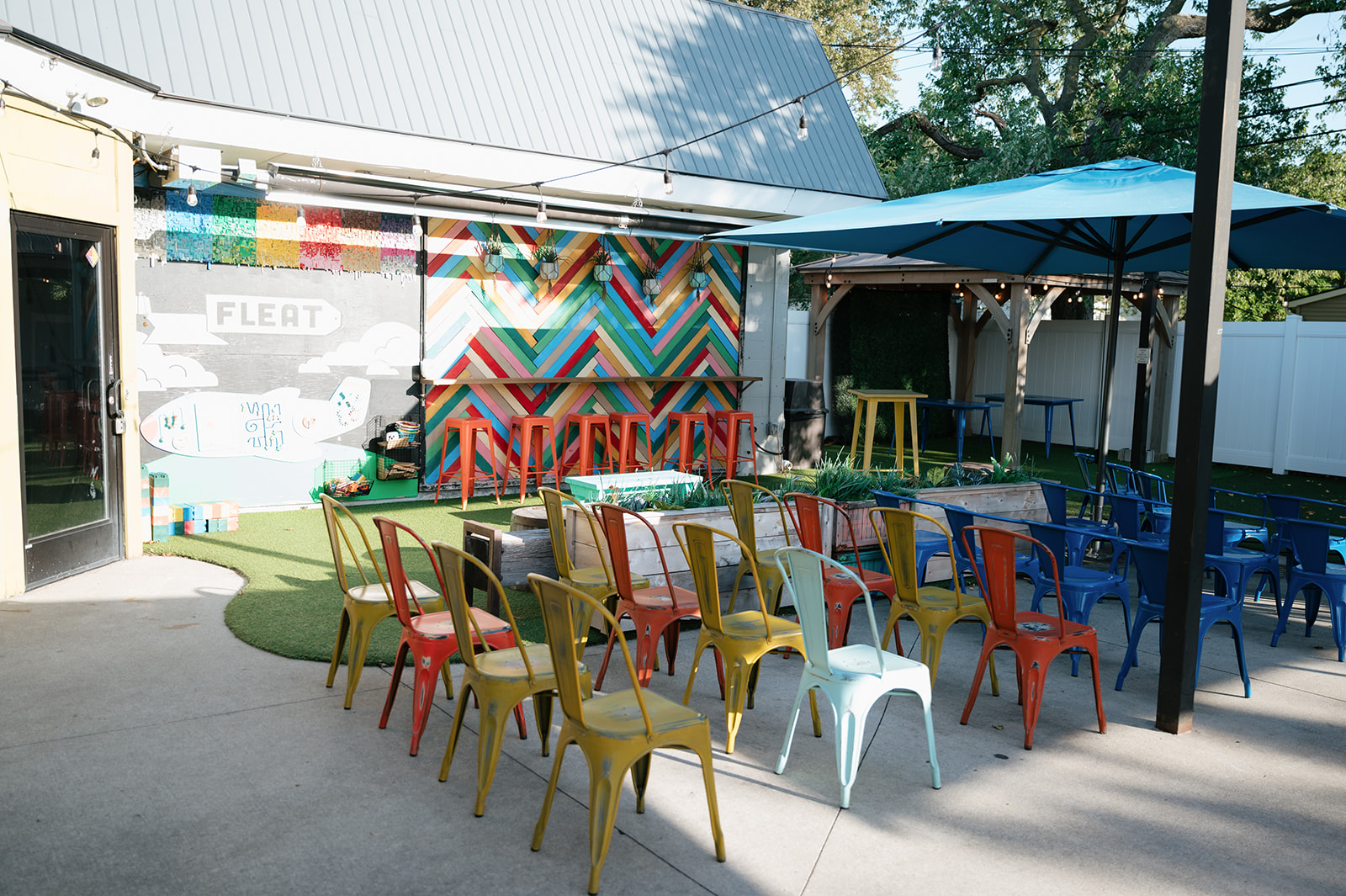 Outdoor ceremony setup with colorful chairs at Detroit Fleat for a Ferndale Michigan wedding.