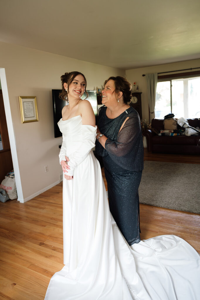 Bride smiling with her mom while getting ready at home before her Livonia wedding.