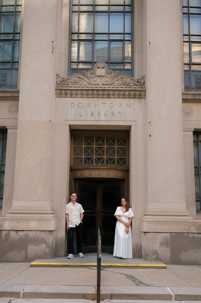 Couple standing outside the Downtown Library during their downtown Detroit engagement photos.