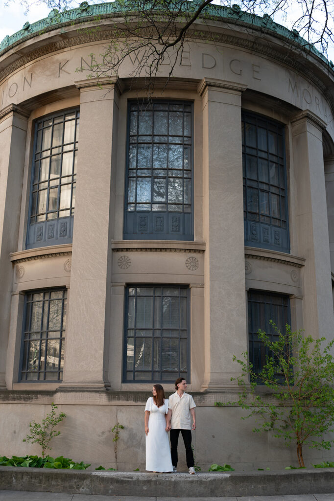 Editorial style photo of a couple posing outside of Downtown Library in Detroit. 