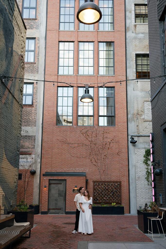 Couple standing together in The Belt during their downtown Detroit engagement photos.