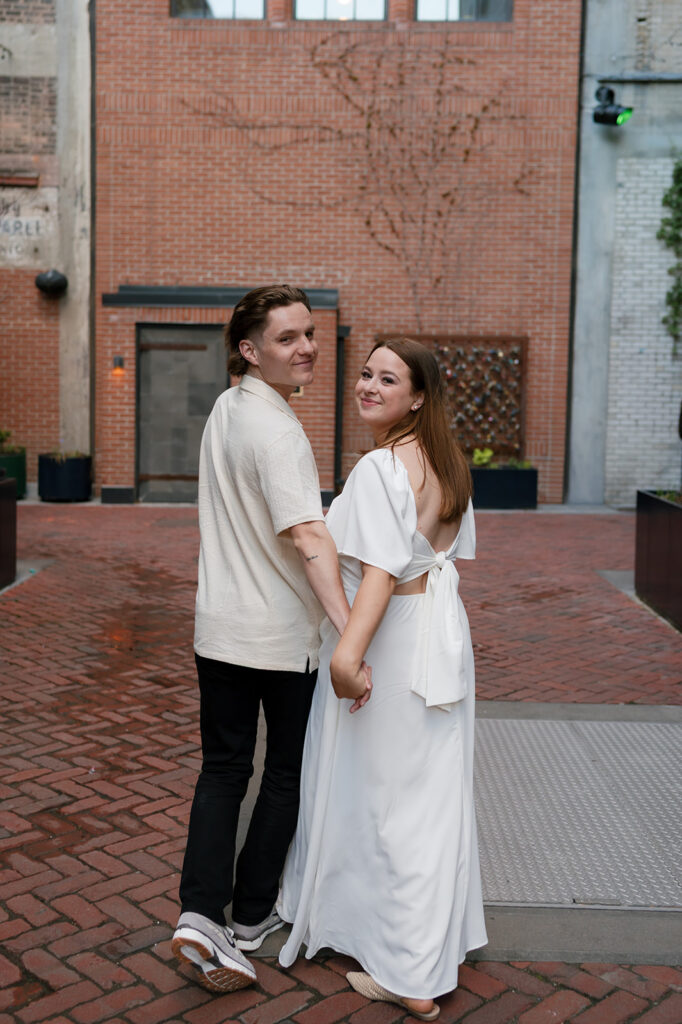 Couple posing in The Belt for their downtown Detroit engagement photos.