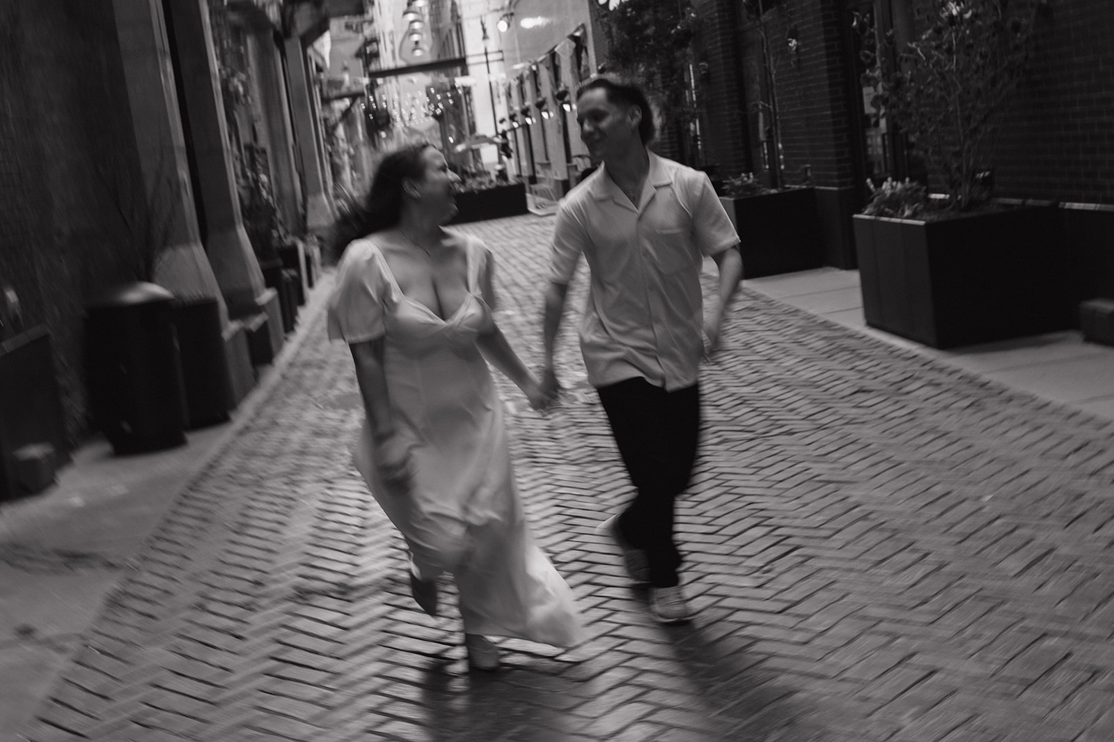 Black and white motion blur photo of a couple running down the Belt in downtown Detroit.