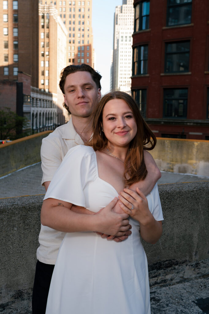 Couple smiling for the camera on a rooftop in Detroit.